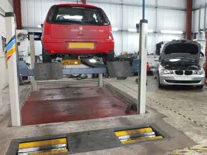 The MOT bay, a red car raised on the lift