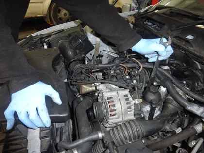 Gloved hands at work in an engine bay