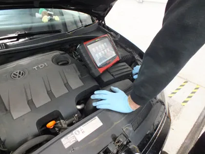 The diagnostic tablet resting on a Volkswagen TDI engine
