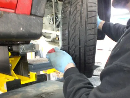 A tester checking a tyre in the MOT bay